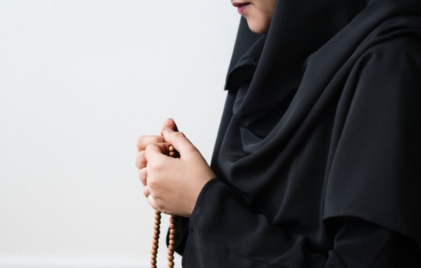 Mujer sosteniendo un rosario